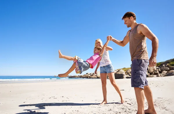 彼らはビーチ愛好家の家族です ビーチで散歩をしている幸せな若い家族が — ストック写真
