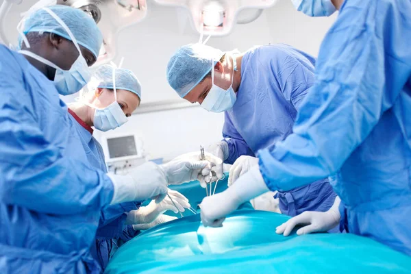 Całkowicie Skupiony Zadaniu Widok Profili Chirurgów Pracujących Razem Fartuchach Sali — Zdjęcie stockowe