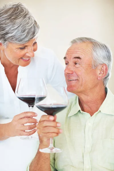 お祝いだ 幸せな成熟した男と女Toastingとともに赤ワイン — ストック写真