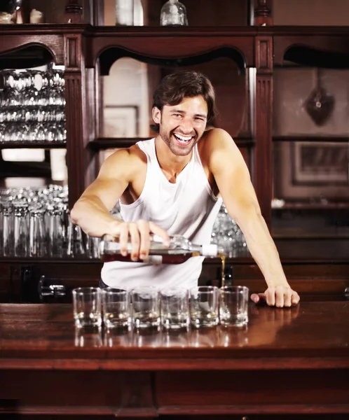 在快乐的时光里 与一位英俊的酒保在酒吧柜台后面为客人提供酒水的肖像 威士忌和酒精 和一个男酒保一起在酒吧里倒威士忌 — 图库照片