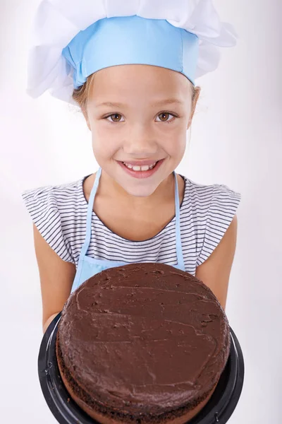 stock image This is more delicious than it looks. Image of a sweet little girl wearing culinary clothes and holding a cake