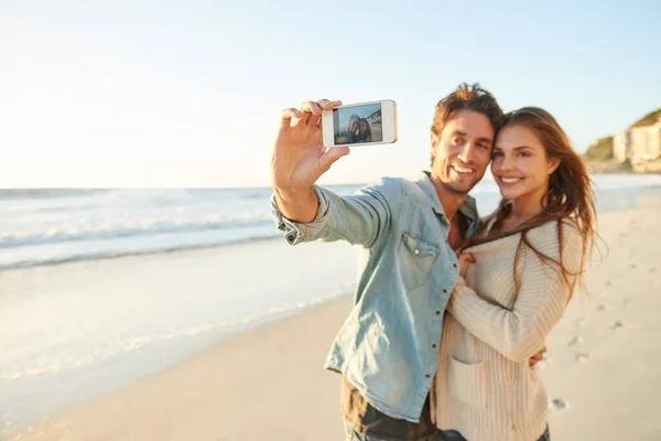 新婚旅行の写真を撮って 若い恋人がビーチで自撮りをしていて — ストック写真
