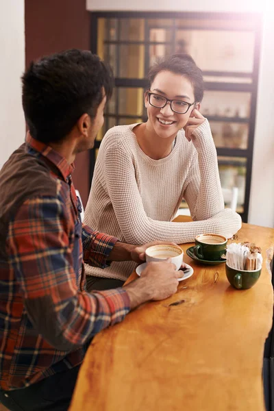コーヒーを飲む人は聞き手を良くする デートで喫茶店に座っている若い夫婦が — ストック写真