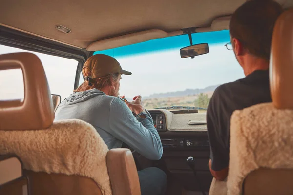 stock image Light up and hit the road. two men smoking together while out on a road trip