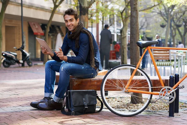 街を繋ぐんだ タブレットを使い自転車で街を散歩している男が — ストック写真