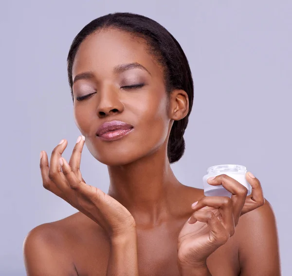 stock image Enhancing her natural beauty. a beautiful young woman against a purple background