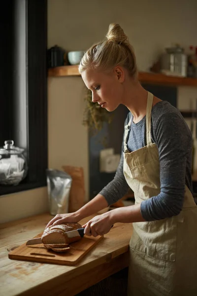 健康的黑麦面包一个在厨房里切面包的年轻女人 — 图库照片