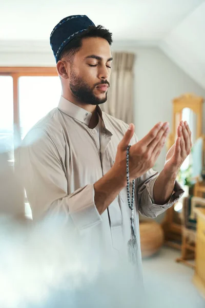 行動の最も強力な道具 自宅のラウンジで祈っていた若いイスラム教徒の男性が — ストック写真