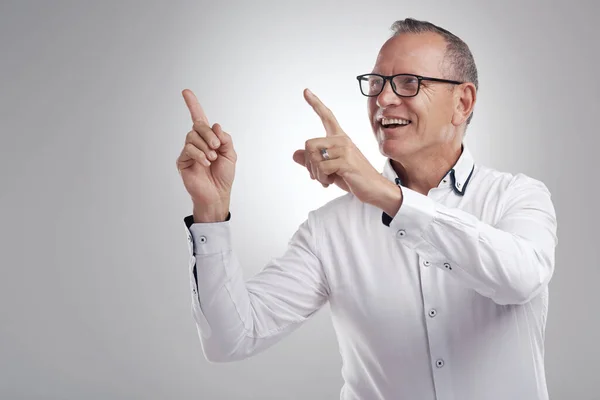 stock image You have got to have this. a handsome mature businessman standing alone against a grey background in the studio and pointing at a promotion