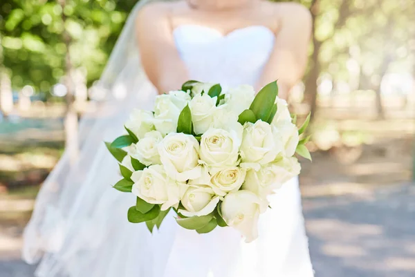 在阳光灿烂的日子里 新娘抱着一束鲜花站在外面 漂亮的白玫瑰结婚花束 — 图库照片