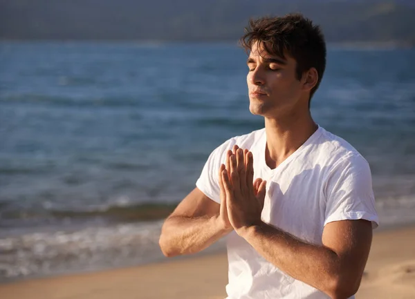 在海滩上找到平衡点一个在海滩上做瑜伽的年轻人 — 图库照片