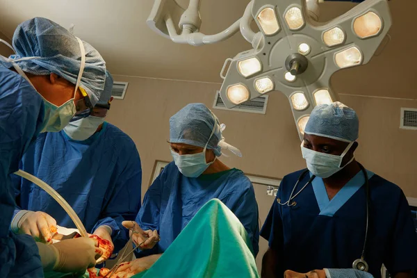 どんな医療緊急事態にも十分対応できる装備 手術室で外科医のチームが手術を行い — ストック写真
