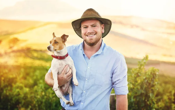 I would choose country life over city life any day. a happy farmer holding his dog