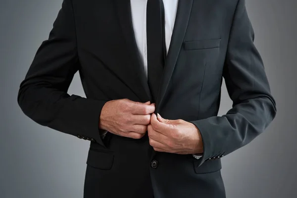 あなたはそれのために服を着て 今それを成功させます 灰色の背景を背景にスーツを着た若いビジネスマンのトリミングされたスタジオショット — ストック写真