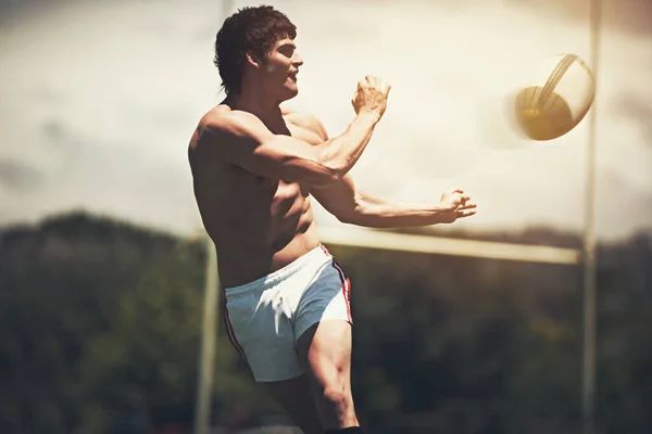 Shirts vs. Skins. a shirtless rugby player executing a pass during a game