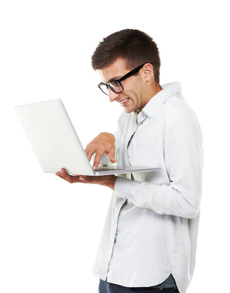 Trying to meet deadlines. A nerdy hipster touching the keys on his laptop with a white background