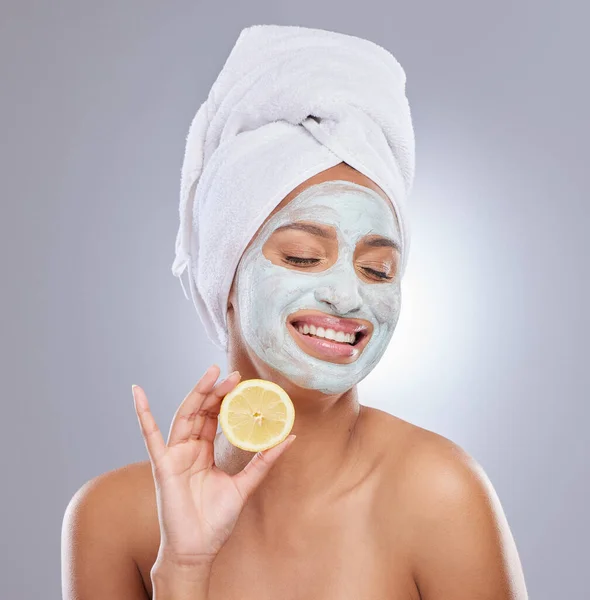 ビタミンCは シミの除去に役立ちます 顔のマスクをした若い女性がスタジオでレモンを持っていて — ストック写真