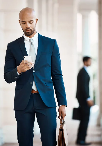 I can do work on the go with my device. a young handsome businessman using a cellphone outside