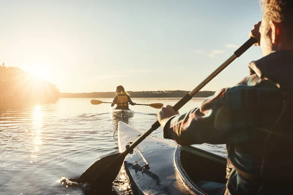 カヤック そして夏の間にボートを漕いでいる人々は 日没のレクリエーションやレジャーのために または休暇中の旅行のためのカヌーで自然 水平線 — ストック写真