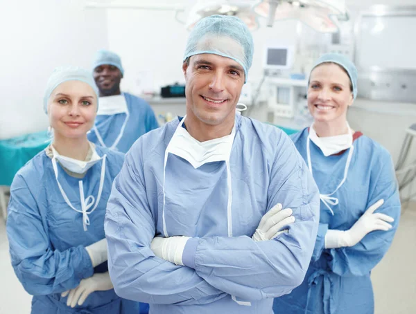 很高兴告诉你这个好消息 在手术室里快乐的外科医生和护士在一起微笑的画像 免版税图库图片