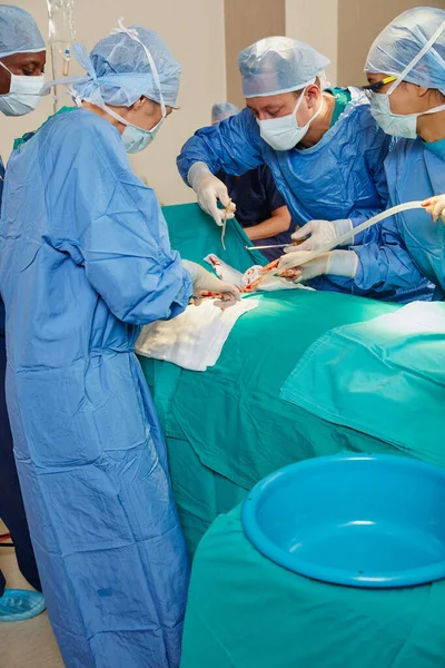 挽救生命的外科医生工作很辛苦 在手术室里做手术的一组外科医生 — 图库照片