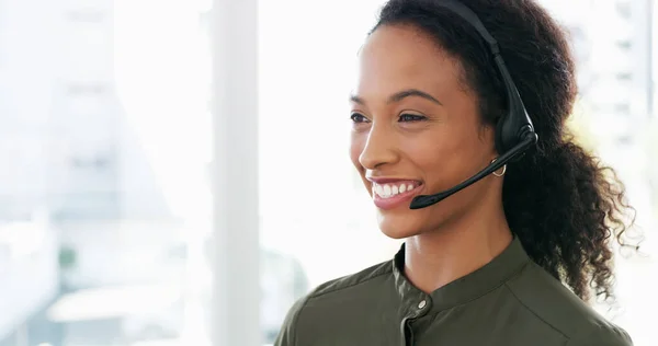 Stock image Resolving queries with a can do attitude. a young woman using a headset in a modern office