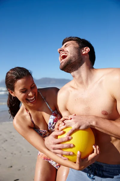 ただの友好的なゲームだ 幸せなカップルがビーチで一緒にボールで遊んでいて — ストック写真