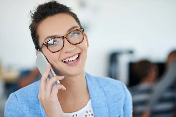 stock image I get off at around 5. an attractive young woman talking on a cellphone in an office