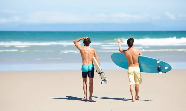 サーフィンに興奮してる ビーチで2人の友人がサーフィンのために水の中に入る準備をしている — ストック写真