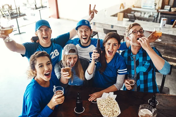 我々は落ち着いていられないゲームは進行中です バーでスポーツの試合を見ながらビールを飲んでいる友人たちが — ストック写真