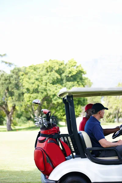 在寻找一个失踪的球 两个人坐在推车里开车穿过高尔夫球场 — 图库照片