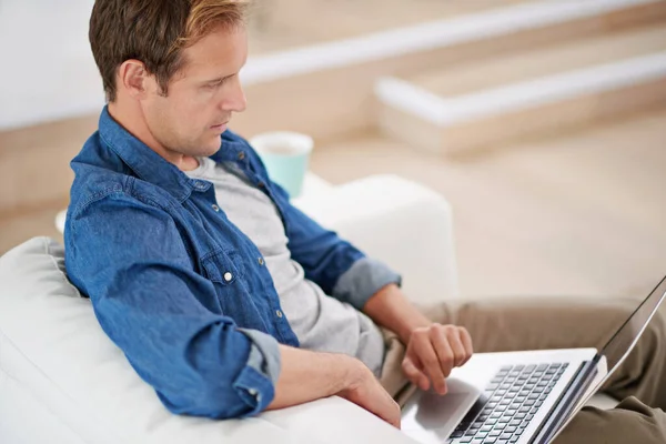 在网上和朋友聊天 一个英俊的男人在家里用笔记本电脑 — 图库照片