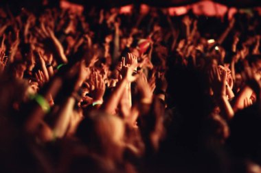 Palpable excitement. An audience with hands raised at an outdoors festival clipart