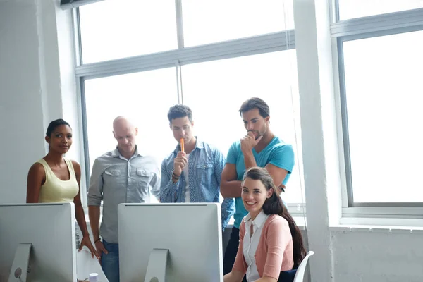 問題解決は彼らの喜びです 計画を実行するためにコンピュータ画面の周りに一緒にオフィスに立っているデザイナーのグループ — ストック写真