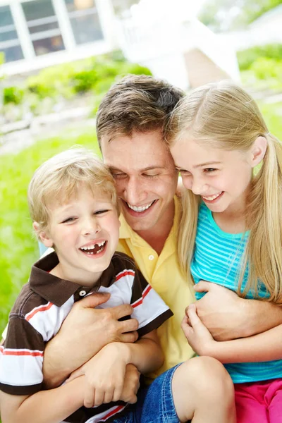 爸爸的小宝藏 英俊的年轻父亲带着幸福的笑容抱着他的两个孩子 — 图库照片