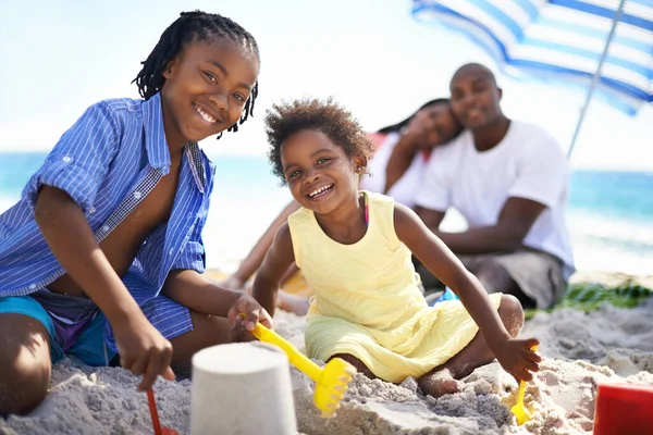 stock image Family day on the beach. An african-american family enjoying a day at the beach and building sand castles
