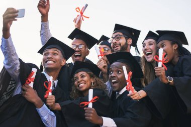 Biz başarımızı herkesle paylaşmak istiyoruz. Mezuniyet gününde selfie çeken bir grup öğrenci.