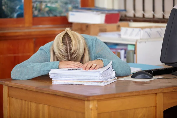 睡在工作上 在她的课桌前散发着标有记号的文件的昏倒的老师 — 图库照片