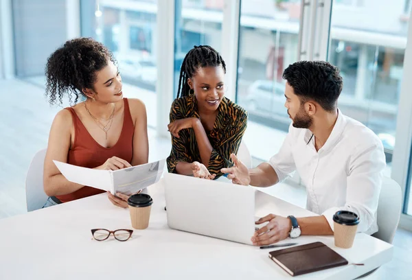 stock image What is your opinion on this. a diverse group of businesspeople sitting in the office and using technology while reading paperwork to strategise