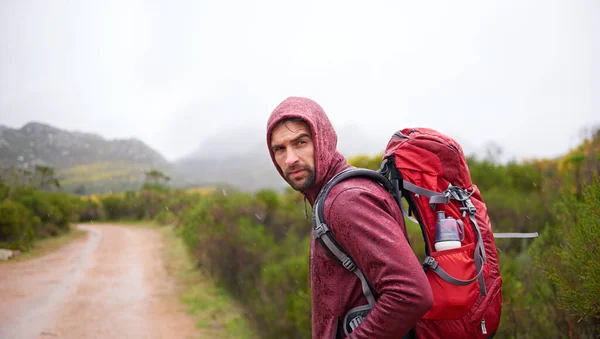振り返ってみると 道路だけで旅した 山の中をハイキングしている若い男が — ストック写真