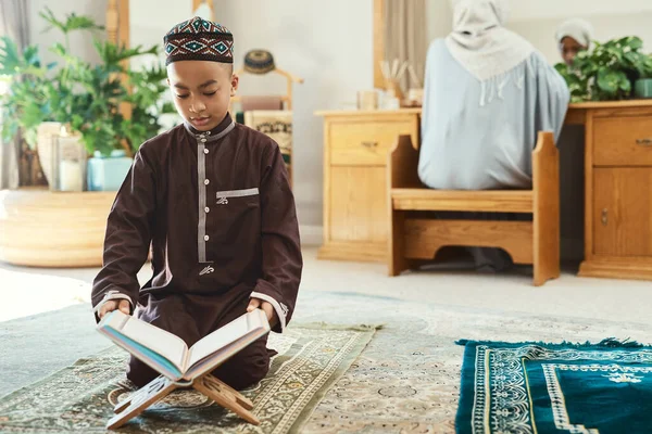 年轻的肩膀上戴着一个聪明的脑袋 一个年轻的穆斯林男孩在家里的休息室看书 — 图库照片