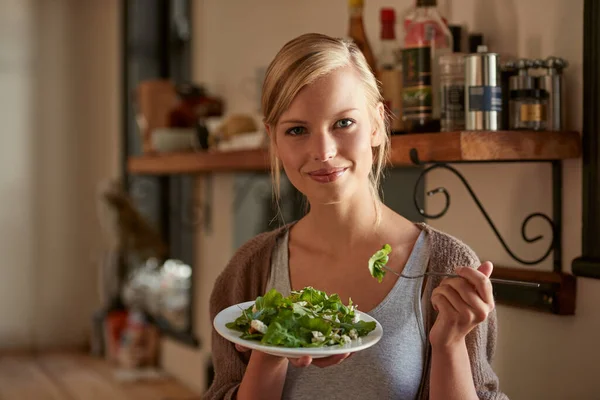 あなた自身で作るとき それは常により良い味 彼女の台所でサラダを食べる魅力的な若い女性の肖像画 — ストック写真