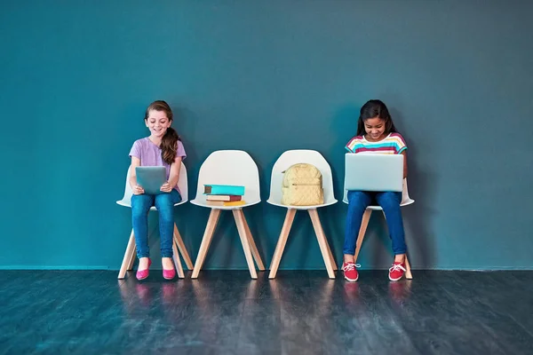 用无线技术支持学校作业 工作室拍摄的孩子们坐在椅子上 在蓝色背景下使用云彩无线技术 — 图库照片
