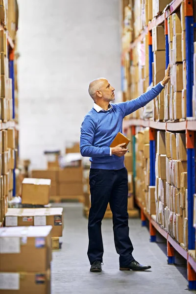Getting orders ready for shipping. a mature man working inside in a distribution warehouse