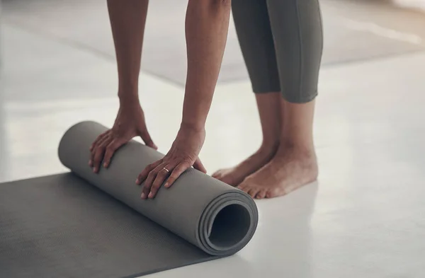 stock image Its been a great yoga session. an unrecognizable woman rolling up her yoga mat after a practice session in her living room