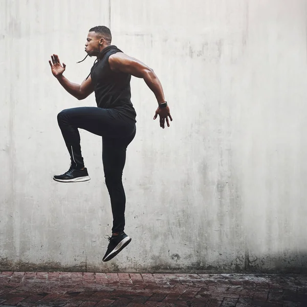 ジャンプ フィットネス 黒人男性のランニング カーディオトレーニング ワークアウト スポーツウェルネスや身体の健康のためのスピードとエネルギー アスリート ランナー コンクリート壁での人の運動 空気中での動作の実行または移動 — ストック写真