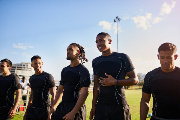 We are confident. a diverse group of sportsmen standing together before playing rugby during the day