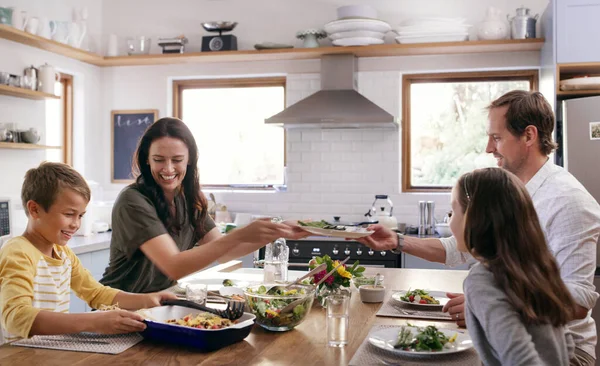 有一些关于家庭餐的事 两个有爱心的年轻父母和他们的孩子在家里厨房里吃饭 — 图库照片