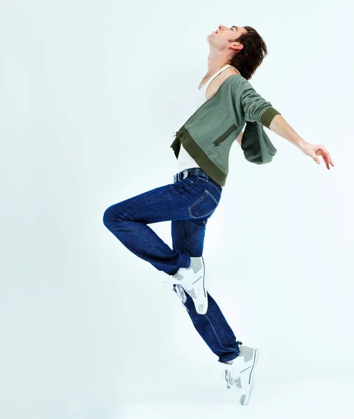 Man, jump and dance in the air for happiness with action, movement and balance of body isolated on white studio background. Male ballet dancer, happy and free with energy or dancing to music for fun.