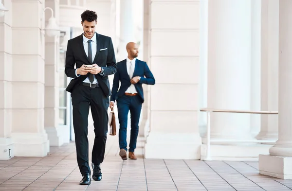 stock image Its all in the grind when it comes to business. a young handsome businessman using a cellphone outside